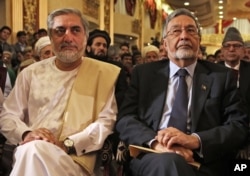 Afghan presidential candidates Abdullah Abdullah, left, and Zalmai Rassoul, right, listen during a news conference in Kabul, May 11, 2014.