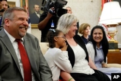 The family of Joshua Holt, who was recently released from a prison in Venezuela, father Jason Holt, left; sister, Marian Leal; mother, Laurie Holt, and his wife, Thamara Holt, right, sit on a couch in the Oval Office of the White House, May 26, 2018, in Washington.