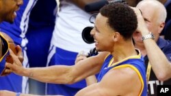 Stephen Curry de Golden State Warriors célèbre après la 4e victoire contre les Cavaliers de Cleveland, qui a donné aux Warriors le trophée, le 16 juin 2015