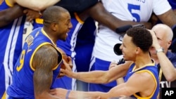 Stephen Curry ( 30 ) , à droite, et Andre Iguodala ( 9 ) célèbrent après avoir remporté le match 6 de la finale de la NBA de basket-ball de Cleveland , le mardi 16 Juin , 2015. Les Warriors ont battu les Cavaliers 105-97 pour gagner le best-of -sept ...