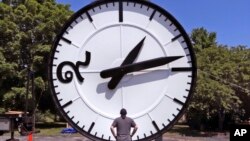 FILE - In this Thursday, July 25, 2019 photo, workers at the Electric Time Company in Medfield, Mass., test a 20 foot high clock, built for the a new train station in Bangkok, Thailand. (AP Photo/Charles Krupa)