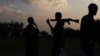 FILE - An armed man and a woman talk in South Sudan, July 24, 2013. 