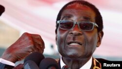 FILE: Zimbabwe's President Robert Mugabe addresses the crowd gathered to commemorate Heroes Day in Harare, Aug. 12, 2013. 