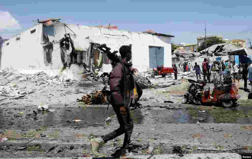 A security officer walks at the scene of an explosion in the Hamarweyne district of Mogadishu, Somalia, Jan. 12, 2022.