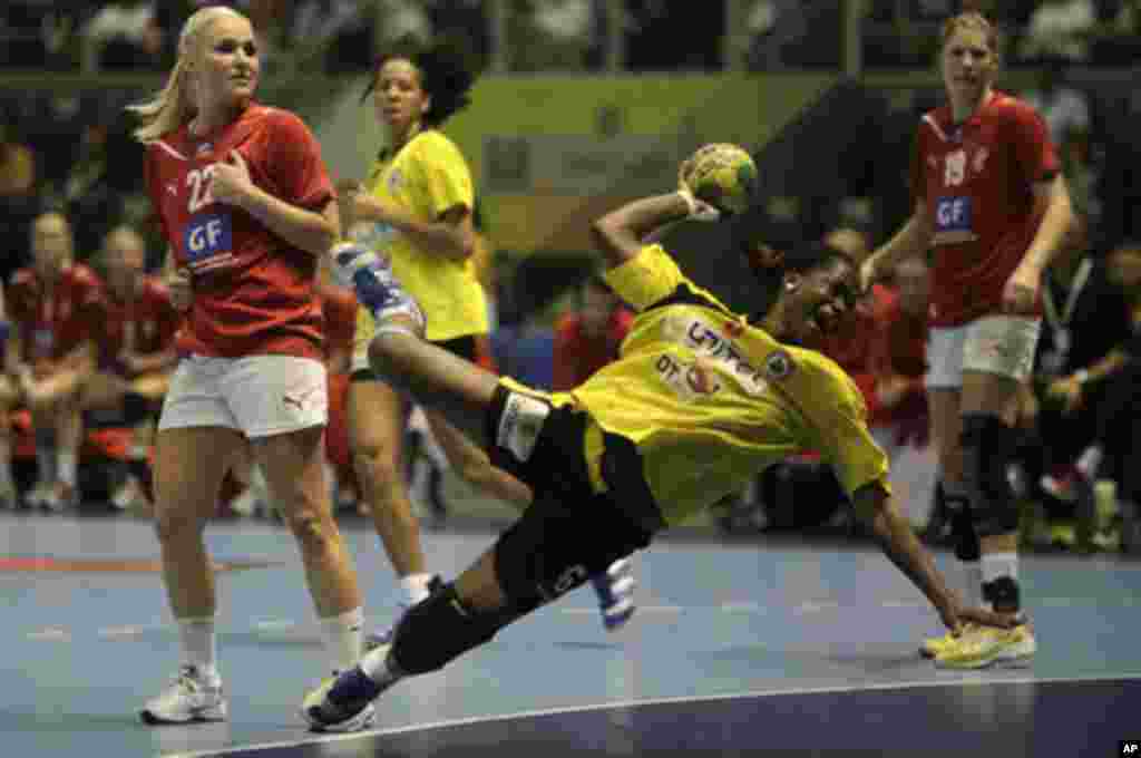 Angola's Madalena Calandula attempts to score as Denmark's players look on during their Women's World Handball Championship quarterfinal match in Sao Paulo December 14, 2011. REUTERS/Ricardo Moraes (BRAZIL - Tags: SPORT HANDBALL)