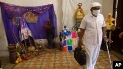 El sacerdote de la santería Lázaro Cuesta permanece de pie tras leer la "Letra del Año", el domingo 2 de enero de 2022, en La Habana, Cuba.