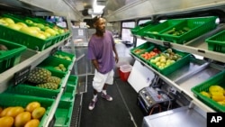 Jock Riggins looks over the fresh fruits and vegetables on the Fresh Stop bus, a mobile market, in Eatonville, Florida, July 15, 2015.