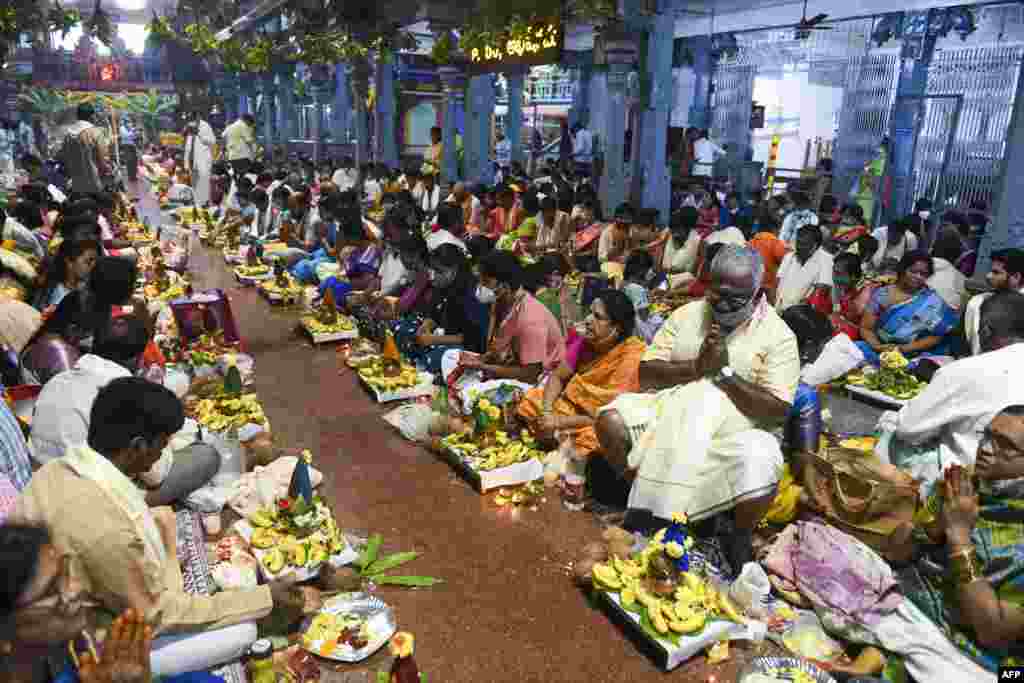 Hindu married couples perform a ritual during Satyanarayana Swami Vratham prayer in a temple in Hyderabad, India.