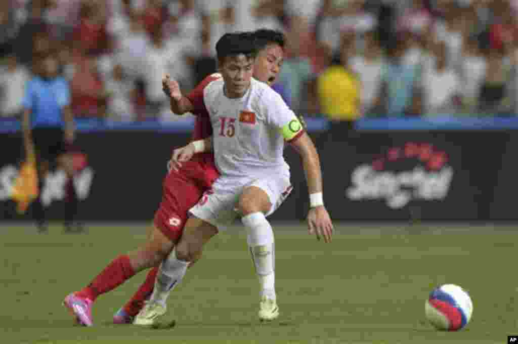 Que Ngoc Hai of Vietnam (15) fouls Nay Lin Tun of Myanmar during their soccer semifinal match at the SEA Games in Singapore, Saturday, June 13, 2015. (AP Photo/Joseph Nair)