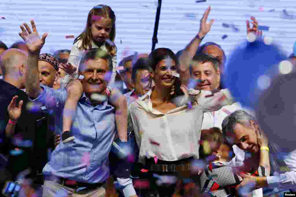 아르헨티나 대통령 선거에서 승리가 확정된 마우리시오 마크리 후보가 딸 안토니아, 부인 줄리아나 아와다와 함께 부에노스 아이레스에서 지지자들의 환호에 답하고 있다.