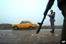 A car is stopped at a checkpoint manned by Ukrainian police officers, in Berdyansk, south coast of Azov sea, eastern Ukraine, Nov. 27, 2018.