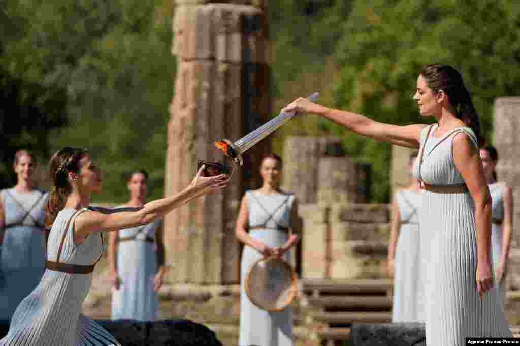 Greek actress Xanthi Georgiou, playing the role of the High Priestess, lights the torch during the flame lighting ceremony for the Beijing 2022 Winter Olympics at the Ancient Olympia archeological site, birthplace of the ancient Olympics in southern Greece.