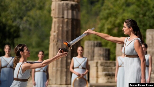Greek actress Xanthi Georgiou, playing the role of the High Priestess, lights the torch during the flame lighting ceremony for the Beijing 2022 Winter Olympics at the Ancient Olympia archeological site, birthplace of the ancient Olympics in southern Greece, Oct. 18, 2021.