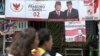 A couple rides a motorcycle past a campaign banners for Indonesian presidential candidate Prabowo Subianto, left, and his running mate Sandiaga Uno in Jakarta, Indonesia, Thursday, Jan. 17, 2019. 