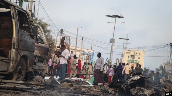 People gather at the scene of twin car bombs that exploded within moments of each other in the Somali capital, Mogadishu, Nov. 9, 2018, near the popular Sahafi Hotel.