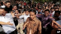 Kandidat presiden Joko Widodo disapa para pendukungnya setelah memberikan suara di Jakarta Pusat, Rabu (9/7). (AP/Dita Alangkara)