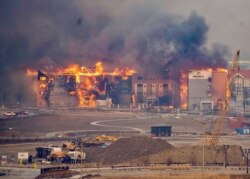 Structures burn, including an Element Hotel, as a wind-driven wildfire forced evacuation of the Superior suburb of Boulder, Colorado, Dec. 30, 2021.