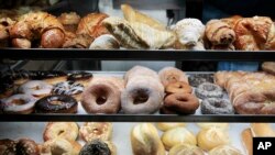 FILE - A selection of donuts, bagels, rolls, croissants, turnovers and sticky buns are displayed in a New York coffee cart, April 10, 2012.