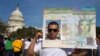 Roberto Morales, 25, holds a sign representing a permanent resident card, while attending the "All in for Citizenship" rally in support of immigration reform in Washington, on April 10, 2013.