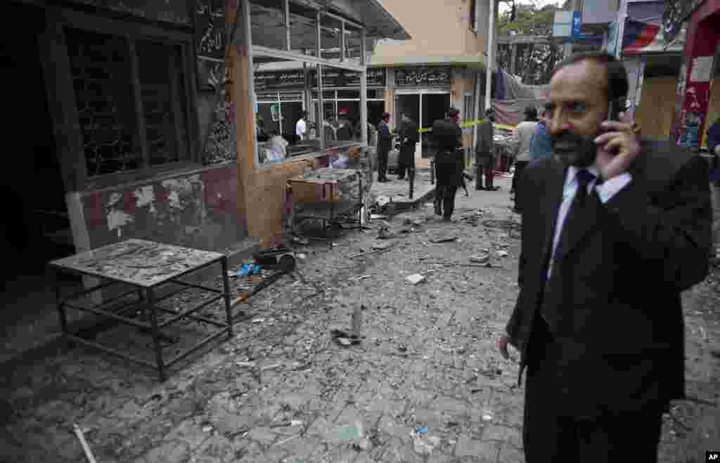 A lawyer talks on his mobile phone at the site of a suicide attack in a court complex, Islamabad, March 3, 2014.