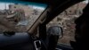 A U.S.-backed Syrian Democratic Forces (SDF) fighter rides past destroyed homes and vehicles in a village recently retaken from Islamic State militants in Susah, Syria, Feb. 16, 2019.