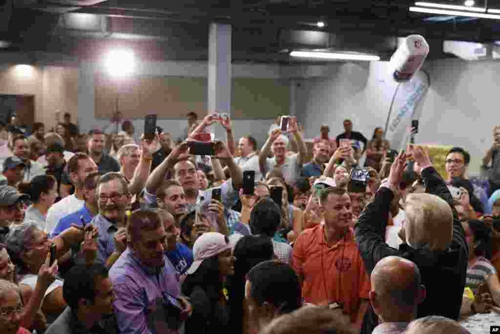 President Donald Trump tosses paper towels into a crowd as he hands out supplies at Calvary Chapel, Oct. 3, 2017, in Guaynabo, Puerto Rico.