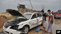 Warga Irak memeriksa lokasi ledakan bom mobil bunuh diri di barat laut kota Kirkuk, 13 April 2014. 