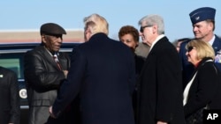 President Donald Trump, second from left, talks with Charles Evers, left, Civil Rights movement activist, after arriving on Air Force One at Jackson-Medgar Wiley Evers International Airport in Jackson, Miss., Dec. 9, 2017.