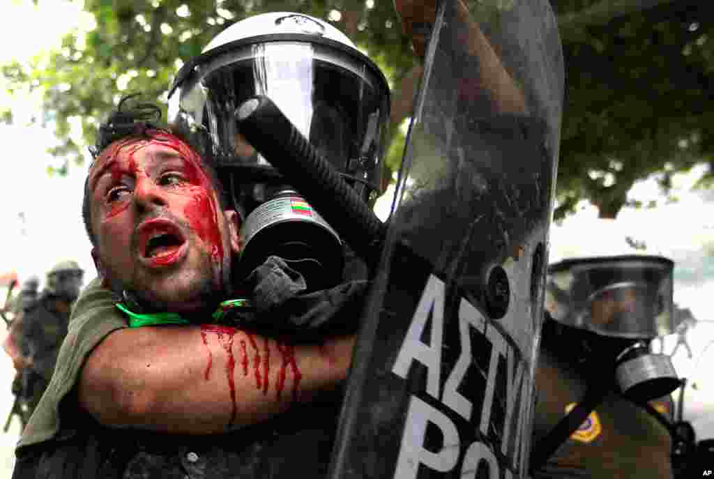 During 2011, residents of Athens, Greece, took to the streets dozens of times to protest austerity measures being considered by the government to prop up the country's failing economy. Pictured is a demonstrator detained by riot police, June 29, 2011. (Re
