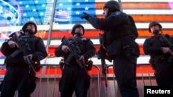 FILE - Armed New York City police officers with the special operation division Strategic Response Group stand guard in Times Square in New York, as security was tightened following the deadly attacks in Paris, Nov. 14, 2015.