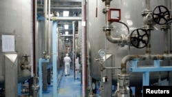 FILE - A technician is seen at the uranium conversion facility in Isfahan, 450 kilometers south of Tehran, Feb. 3, 2007. The Isfahan nuclear research center is already home to three reactors.