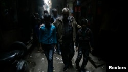 FILE - Bonded child labourers are escorted by a policeman (C) after they were rescued during a joint operation conducted by police and a non-governmental organisation (NGO) in New Delhi, December 10, 2009.