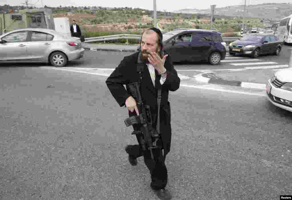 An Ultra-Orthodox Jewish man runs at the scene where a Palestinian attacked civilians with a chemical substance near the West Bank Jewish settlement of Neve Daniel, Dec. 12, 2014.