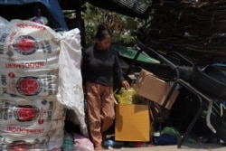 Ou Ran is pictured looking for recycling bottles, cans, paper, plastic, and other kinds of scraps along a road located in the northern part of Phnom Penh, Cambodia, April 22, 2020. (Phorn Bopha/VOA Khmer)