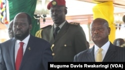 South Sudanese President Salva Kiir (left) watches an Independence Day parade in Juba on July 9, 2014 with Ugandan President Yoweri Museveni (right). 