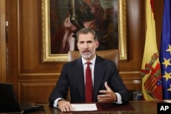 In this image released by the Spanish Royal Palace, Spain's King Felipe VI delivers a speech on television from Zarzuela Palace in Madrid, Oct. 3, 2017.