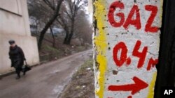 FILE - A woman walks past a gas-metering point in Chisinau, Moldova.