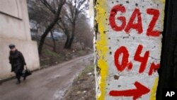 FILE - As Russian-Ukranian billing dispute leaves over 15 European nations scrambling for alternative sources, woman walks past gas metering point in Chisinau, Moldova, Jan. 16, 2009.