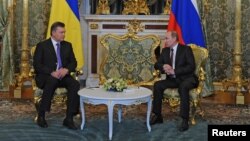 FILE- Russia's President Vladimir Putin (R) speaks with his Ukrainian counterpart Viktor Yanukovych during their meeting in the Kremlin in Moscow, on Dec. 17, 2013