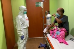 Dokter Cheras Sjarfi berbincang dengan seorang pasien di ruang isolasi di tengah lonjakan kasus baru COVID-19, di sebuah rumah sakit di Jakarta, 1 Juli 2021. (Foto: Yuddy Cahya/Reuters)