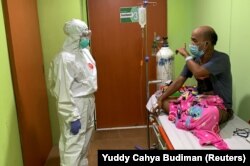 Dokter Cheras Sjarfi berbincang dengan seorang pasien di ruang isolasi di tengah lonjakan kasus baru COVID-19, di sebuah rumah sakit di Jakarta, 1 Juli 2021. (Foto: Yuddy Cahya/Reuters)