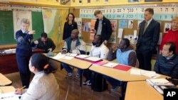 FILE - Teacher Yvette Rainville, of the Vermont Refugee Resettlement Program, instructs students in an English-language class on the basics of traffic signs as others - including Vermont Gov. Peter Shumlin, standing at right - observe, in Burlington, Vermont, Nov. 24, 2015.