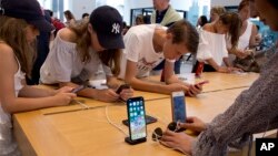 FILE- Customers browse in an Apple store in New York, Aug. 2, 2018. On Thursday, the Commerce Department issued its July report on consumer spending, which accounts for roughly 70 percent of U.S. economic activity.