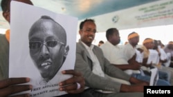 Somali jurnalistlari hibsga olingan hamkasbi suratini ushlab turibdi. 27-yanvar 2013-yil. 