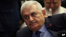 FILE - Binali Yildirim, Turkey's Transportation Minister and founding member of Turkey’s governing AKP party, participates in a meeting in Ankara, Turkey, May 12, 2016.