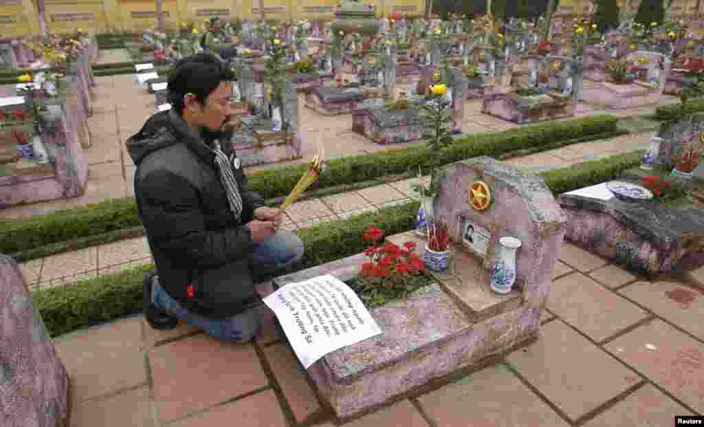 Anti-China protester Anh Chi prays at the grave of Nguyen Xuan Chinh who died during the border war of China and Vietnam, at a military cemetery outside Hanoi February 16, 2014.