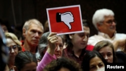 A voter holds up a sign during a town hall meeting with constituents by U.S. Representative Leonard Lance, R-N.J., in Cranford, New Jersey, May 30, 2017.