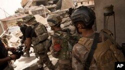 FILE - Iraqi special forces advance to the Islah al-Zarai area in Mosul, Iraq, May 11, 2017.
