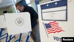 FILE - A voter casts his ballot behind a ballot booth during the U.S. presidential election at a polling station in the Staten Island Borough of New York, U.S. 