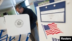 FILE - A voter casts his ballot behind a ballot booth during the U.S. presidential election at a polling station in the Staten Island Borough of New York, U.S.